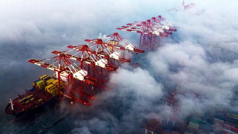 Cargo ships and cranes are partially obscured by fog at the Port of Shanghai on Feb. 16, 2025