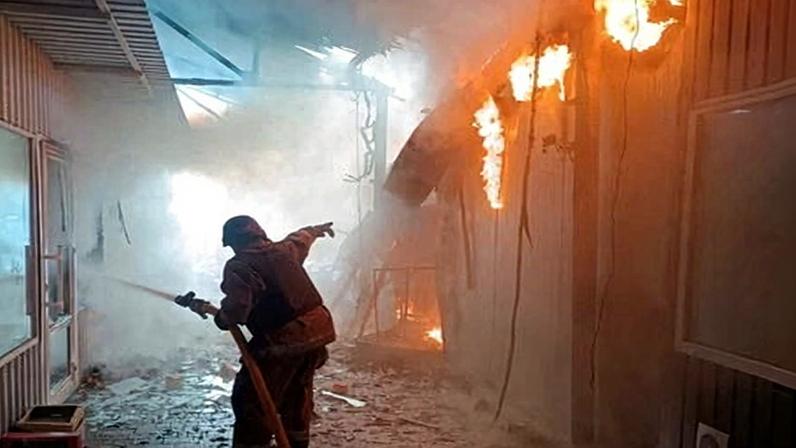 A firefighter works at a street market hit by a Russian drone strike, amid Russia's continuing war on Ukraine.