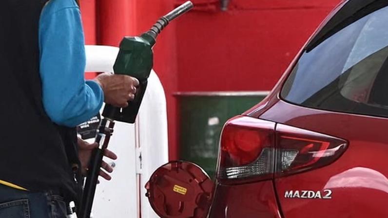 A customer uses a fuel pump to fill up a car. A two-week compliance blitz has seen inspectors visit about 75% – or just under 1,800 – of stations registered with fuel price app FuelCheck in NSW.