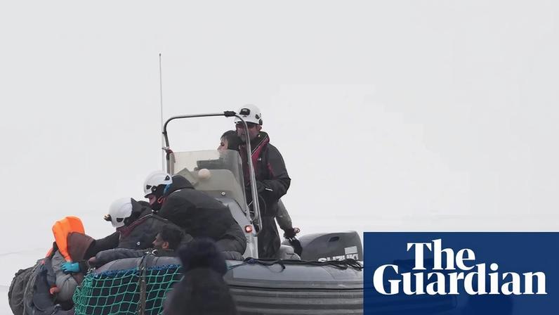 Members of the French authorities pull people into a boat during a rescue operation off the coast of Gravelines, France.