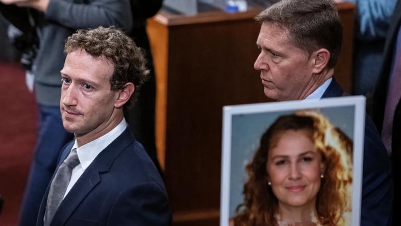 Mark Zuckerberg walks past the photo of a victim of child exploitation at a Senate committee hearing last year.