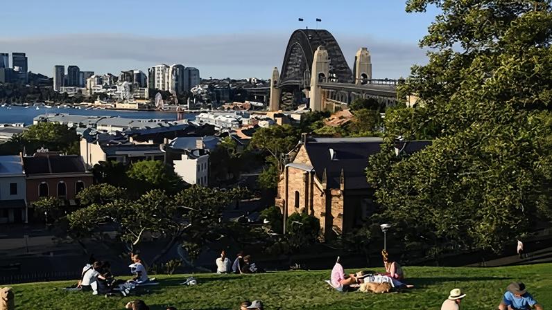 People having picnics on lawns overlooking the Sydney Harbour Bridge