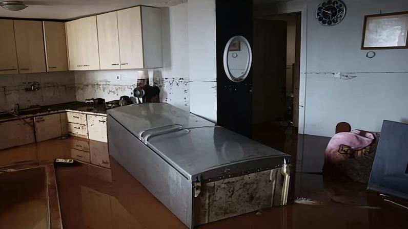 A refrigerator floats inside a flooded property the town of Nea Makri, near Athens, after Storm Erminio.