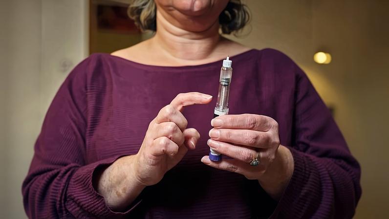 A woman prepares for a subcutaneous self-injection. Retatrutide, which is in clinical trials, targets three appetite-related hormones.