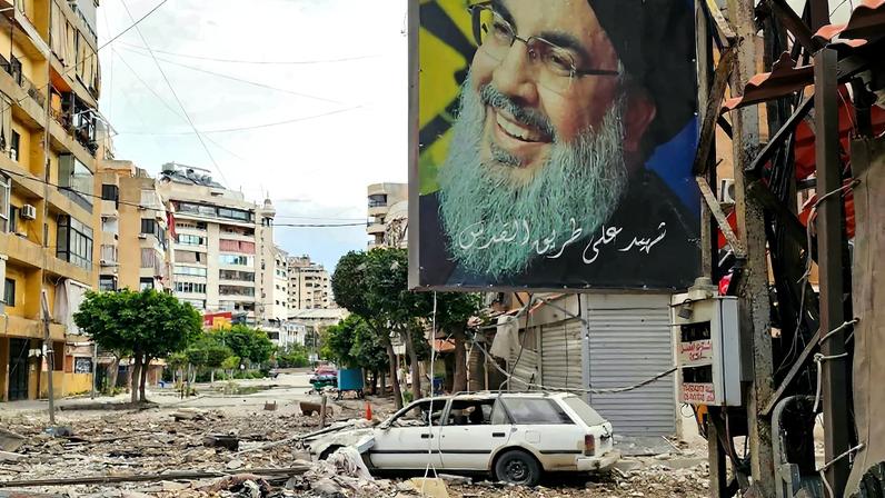 A banner bearing the image of assassinated Hezbollah leader Hassan Nasrallah hangs from a building at the site of an Israeli airstrike in Beirut’s southern suburbs on March 25. AFP via Getty Images