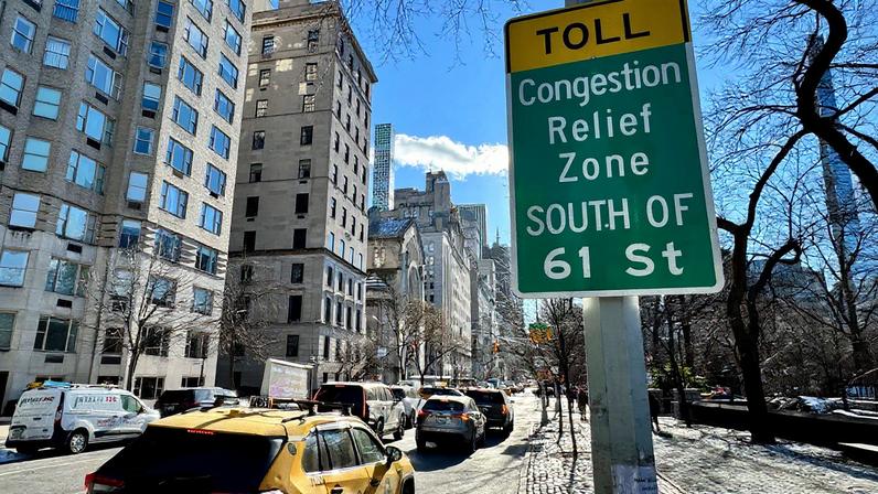 A NYC sign says, “Toll; congestion Relief Zone south of 61st street.”