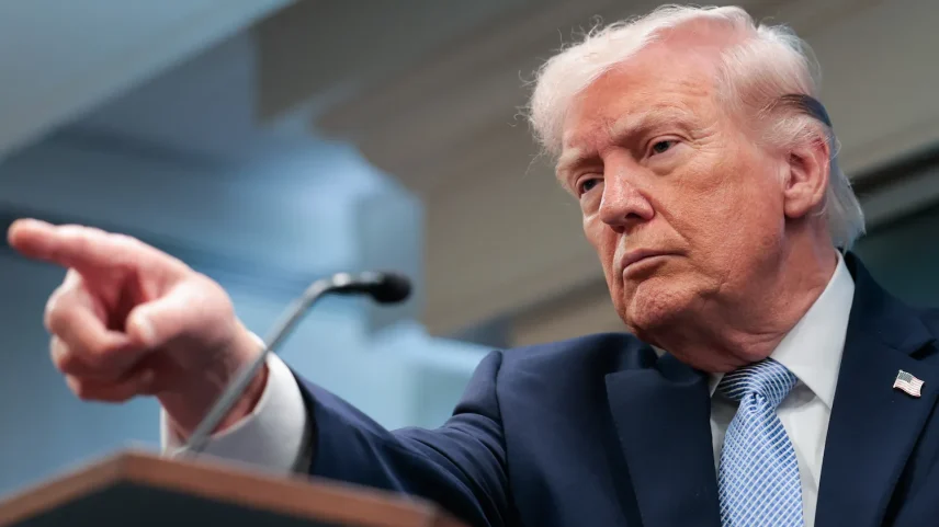 U.S. President Donald Trump points while standing in front of a podium.