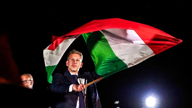 Peter Magyar waves a Hungarian flag after delivering his victory speech following parliamentary elections in Budapest.
