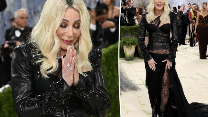Cher attends the 2026 Met Gala in a black ensemble featuring a leather jacket, corset, sheer skirt, and lace tights.