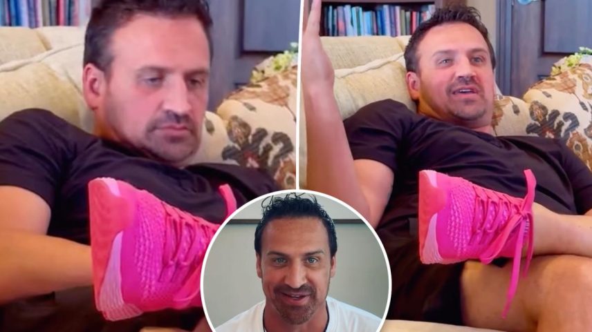 Ryan Lochte in a black shirt, resting on a couch, holding up a pink shoe.