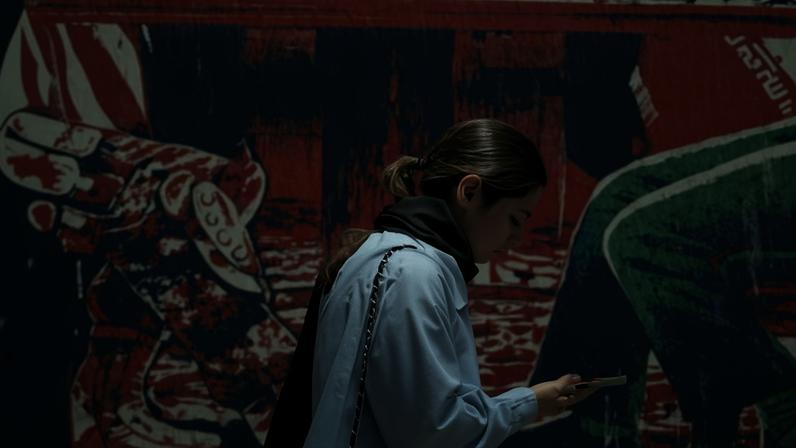 A girl walks past an anti-US mural depicting Iran and US negotiations at a table, near the former US embassy in Tehran.