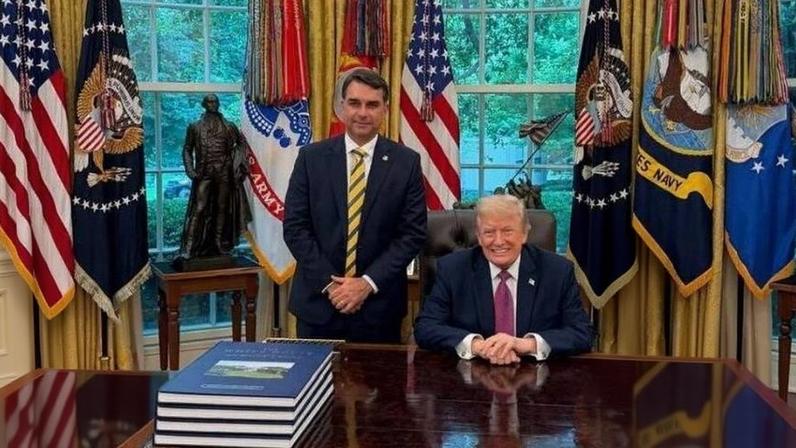O senador Flávio Bolsonaro (PL-RJ) e o presidente dos Estados Unidos, Donald Trump, na Casa Branca. Para Igor Gielow, a foto não terá efeito, e o caso Dark Horse seguirá perseguindo o primogênito de Jair Bolsonaro