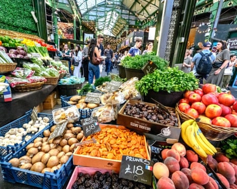 A Borough Market stall displaying fruit and vegetables in baskets and crates