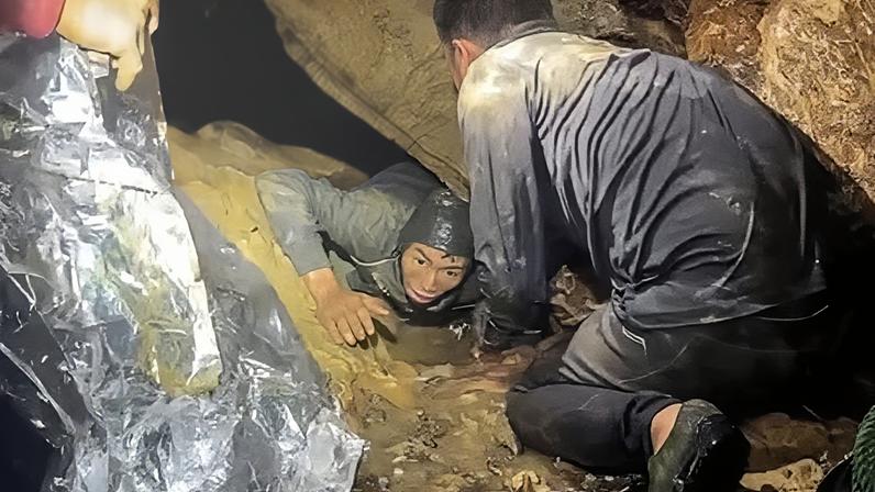 One of the seven trapped men emerges from the cave.