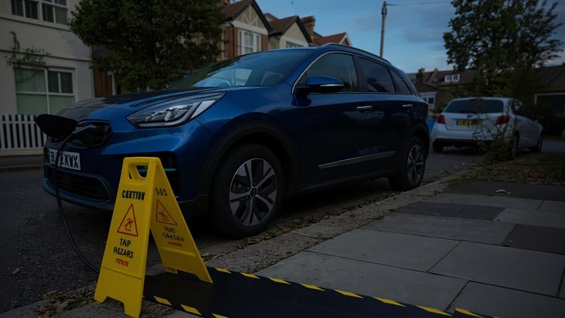 An electric car is charged on a residential street in London using pavement cable protectors. Gully makers say their products remove the trip hazard.