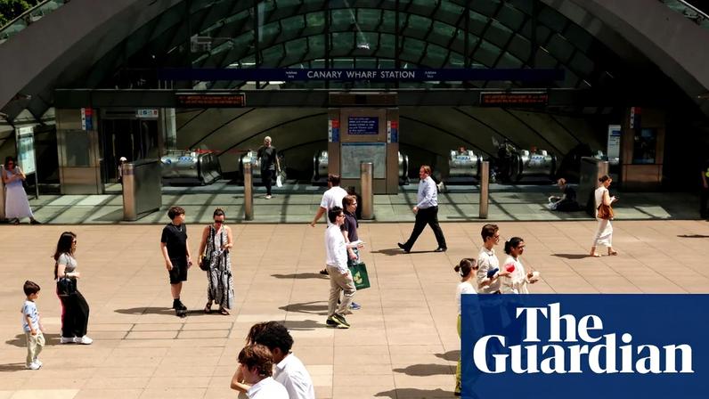 People walk across a plaza in Canary Wharf during a heatwave
