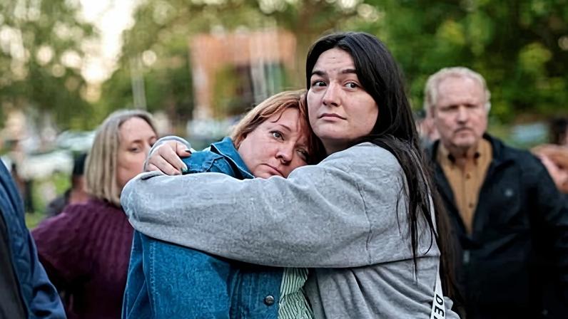 Diana Winther, left, and Kellie Webber, embrace during an evening prayer and vigil in Longview, Washington, in support of the victims of the paper mill disaster.