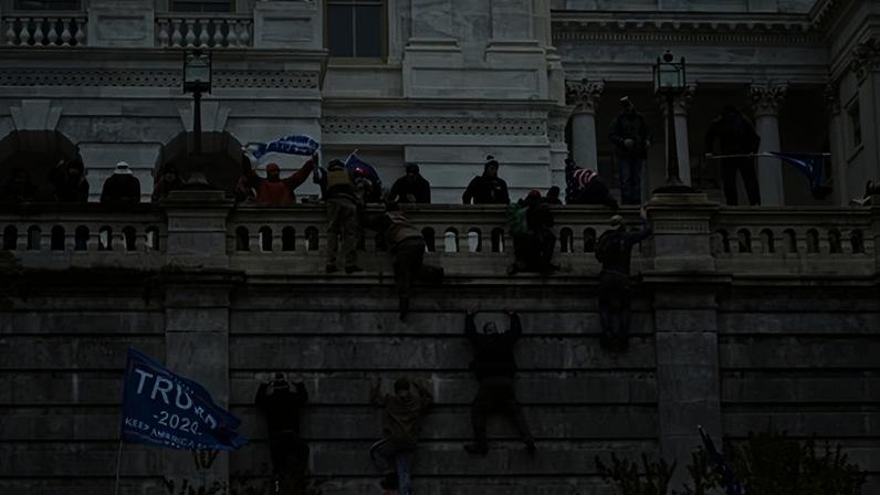 Supporters of Donald Trump scale the west wall of the the US Capitol as they try to storm the building on 6 January 2021.