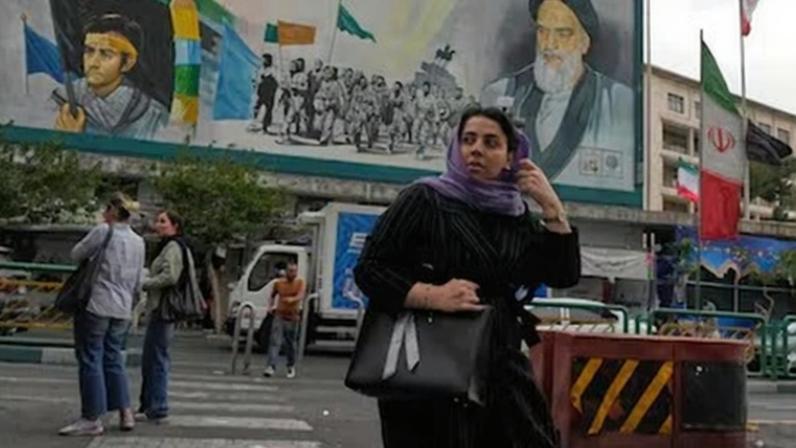 Una mujer en las calles de Teherán, delante de un retrato del ayatolá Jomeiní, el domingo.