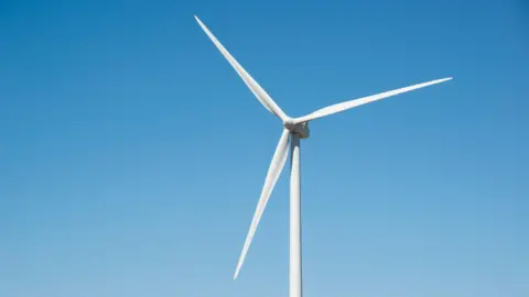 Getty Images A lone wind turbine against a blue sky