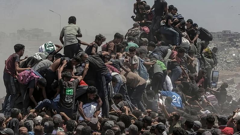 Displaced Palestinians jostle for bags of flour from an aid truck near a food distribution point in the northern Gaza Strip in July 2025.