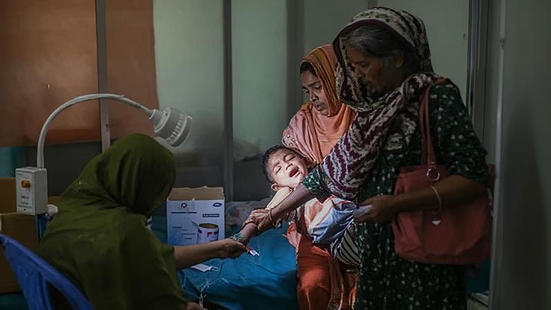 A child receives treatment for measles at a Dhaka hospital. Cuts to foreign aid by the UK, France and Germany could contribute to millions of preventable deaths, according to the report.