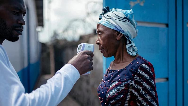Integrante de equipe médica examina mulher com termômetro para afastar suspeita de contaminação pelo ebola na República Democrática do Congo – foto: Jospin Mwisha/AFP