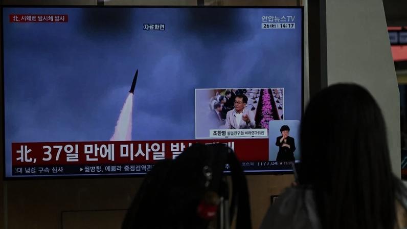 Mulher em Seoul assiste a uma matéria sobre lançamento de mísseis da Coreia do Norte, em 26 de maio de 2026. Foto: Pedro Pardo/AFP