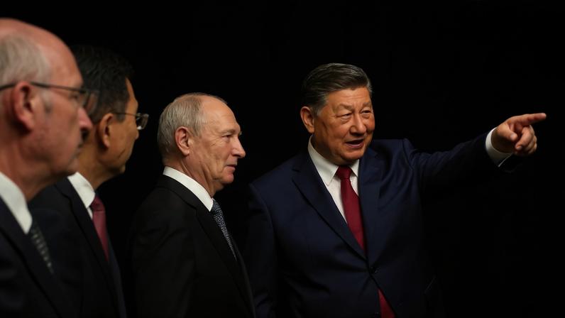 In a pool photograph distributed by Russian state agency Sputnik, Russian President Vladimir Putin and Chinese President Xi Jinping tour a photo exhibition on Russia-China ties in Beijing on May 20.