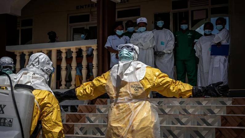 Profissionais de saúde recebem spray com desinfetante após contato com o corpo de uma pessoa suspeita de ter morrido de ebola, na RDC, em 25 de maio de 2026. Foto: Glody Murhabazi/AFP