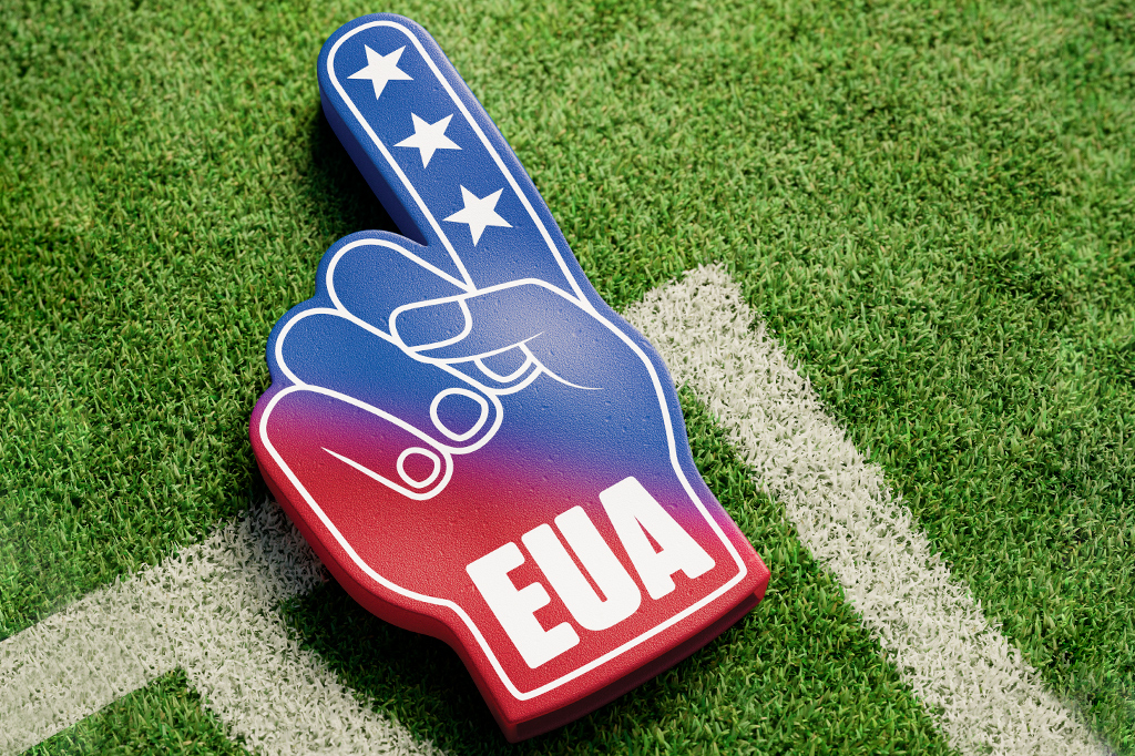 Ilustração 3D de uma mão de espuma de torcida com as cores da bandeira dos EUA e a sigla "EUA" em branco, sobre gramado verde na marca de escanteio.