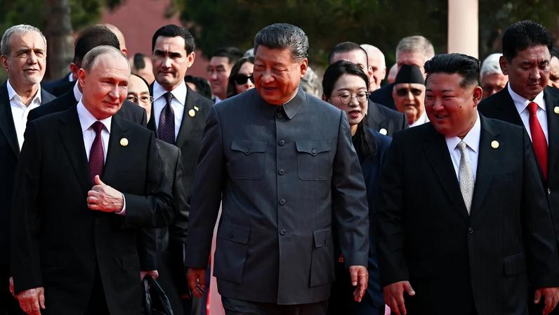In this pool photograph distributed by the Russian state agency Sputnik, from left to right, Russian President Vladimir Putin walks with Chinese President Xi Jinping and North Korean leader Kim Jong Un in Tiananmen Square in Beijing.