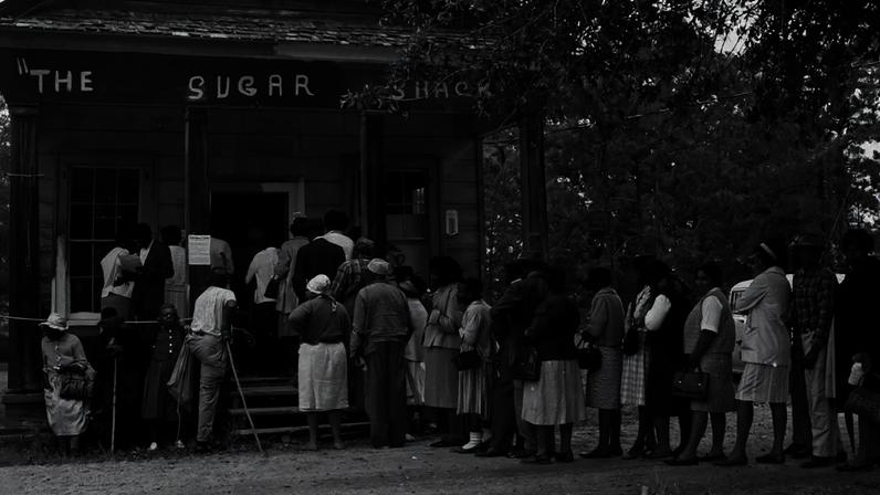 A group of Black voters line up outside a polling station in a small store in Peachtree, Alabama, on May 3, 1966.
