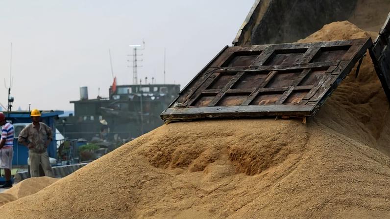 Trabalhador observa o transporte de soja importada em um porto em Nantong, província de Jiangsu, China