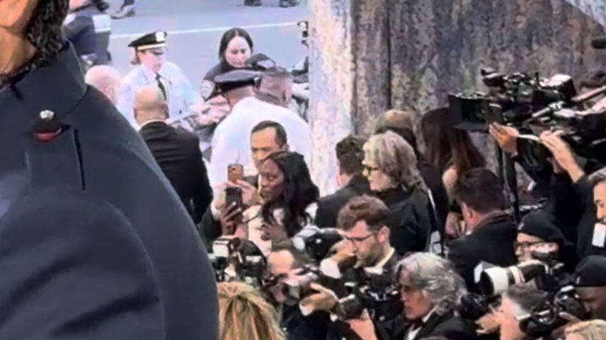 An anti-Bezos protester rushed the red carpet at the Met Gala. Police and protesters are seen scuffling in the background above.