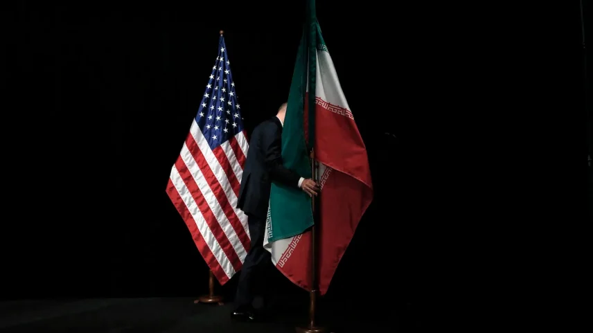 A staff member removes the Iranian flag from the stage during Iran nuclear talks in Vienna on July 14, 2015.