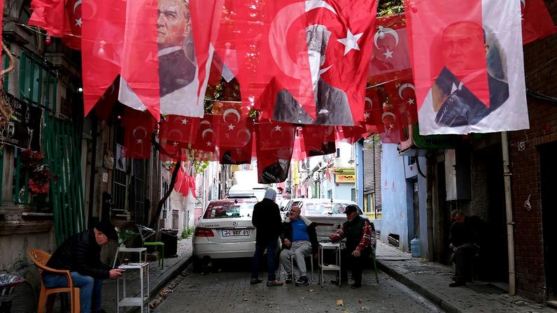 Flags and portraits of Mustafa Kemal Ataturk, the founding father of the Turkish Republic, hang above a small alleyway in the Balat neighborhood of Istanbul on Nov. 20, 2024.