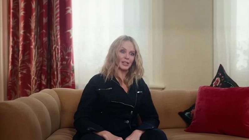 Kylie Minogue sitting on a couch.