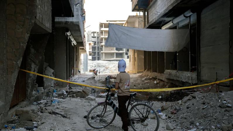 A child looks at a massacre site that is taped off and guarded in Tadamon, Syria, on May 9. Kate Brooks photos for Foreign Policy