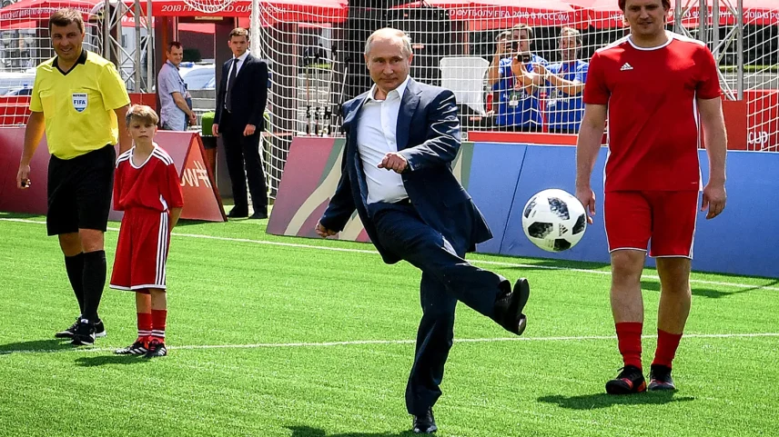 Russian President Vladimir Putin kicks a ball as he takes part in the opening of an exhibition soccer match before the World Cup in Moscow's Red Square on June 28, 2018.