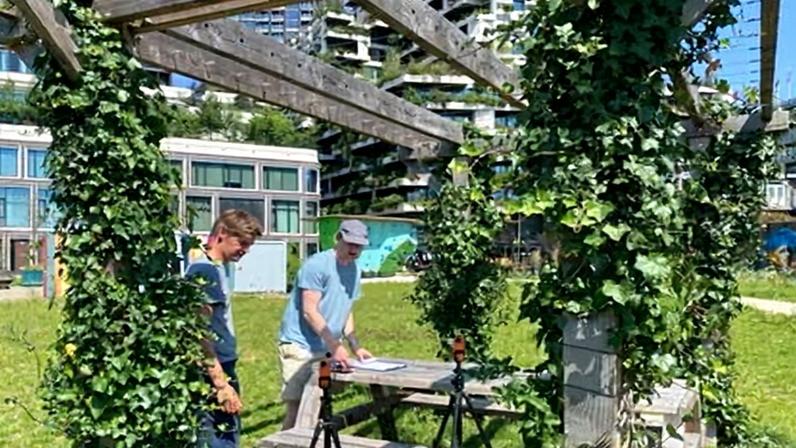 Researchers in Utrecht working next to a pergola covered with greenery.