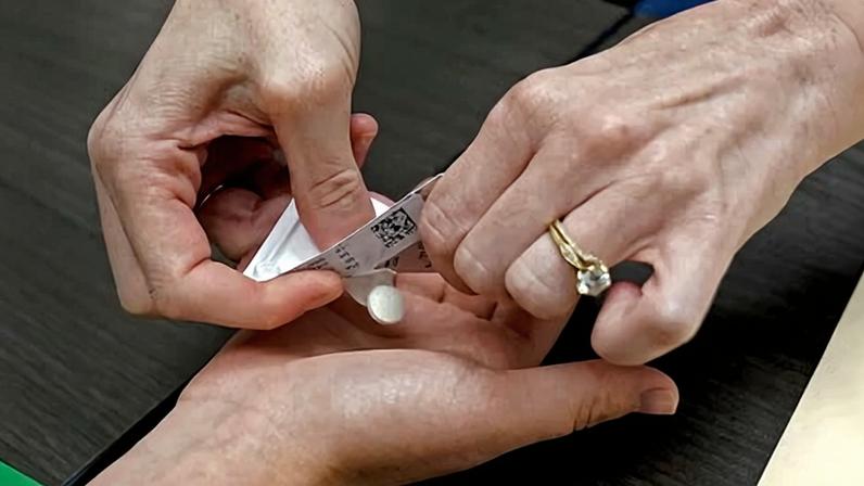 A doctor hands a patient the first of two pills taken for a medical abortion.