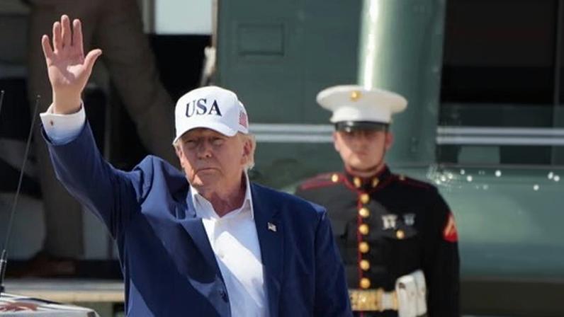President Donald Trump waves as he arrives on Marine One at Joint Base Andrews.