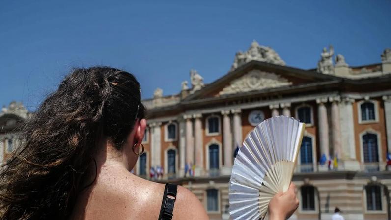 A person holds a fan in Toulouse, southern France, amid soaring temperatures in Europe. Follow live for latest news and updates on the European heatwave.