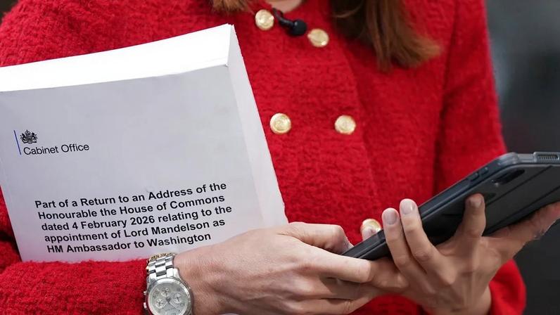 A journalist holds a copy of part of the collection of messages and emails that concern the appointment of Peter Mandelson.