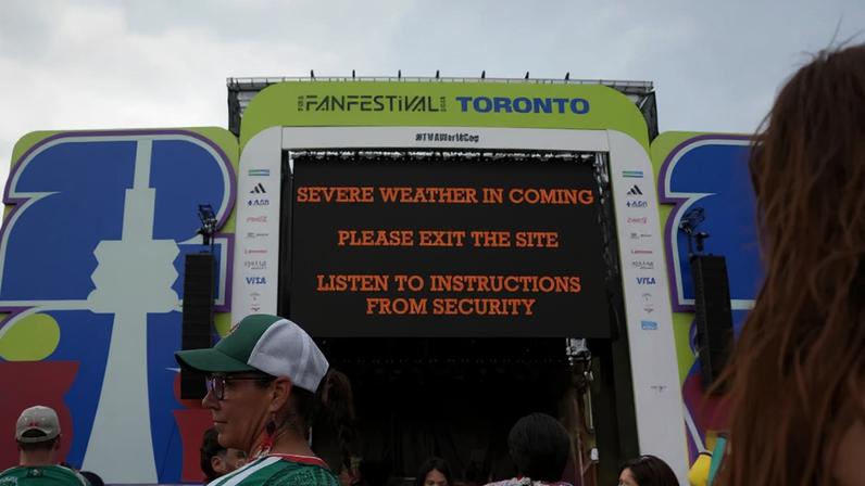 People leave a fan festival area in Toronto, Ontario, after it was cancelled during the first half of the opening World Cup match due to bad weather