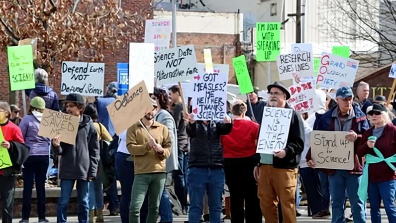 Stand for Science protesters carrying signs opposing cuts to scientific research by the Trump administration.