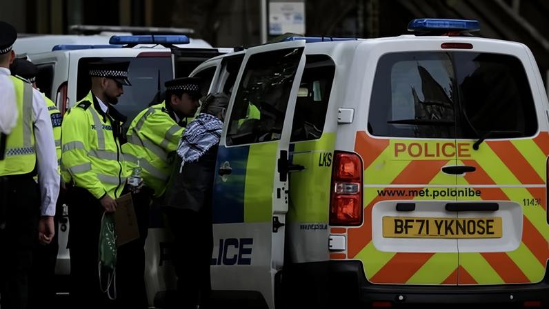 Metropolitan police officers detain a pro-Palestine demonstrator outside the Royal Courts of Justice in London on Monday.