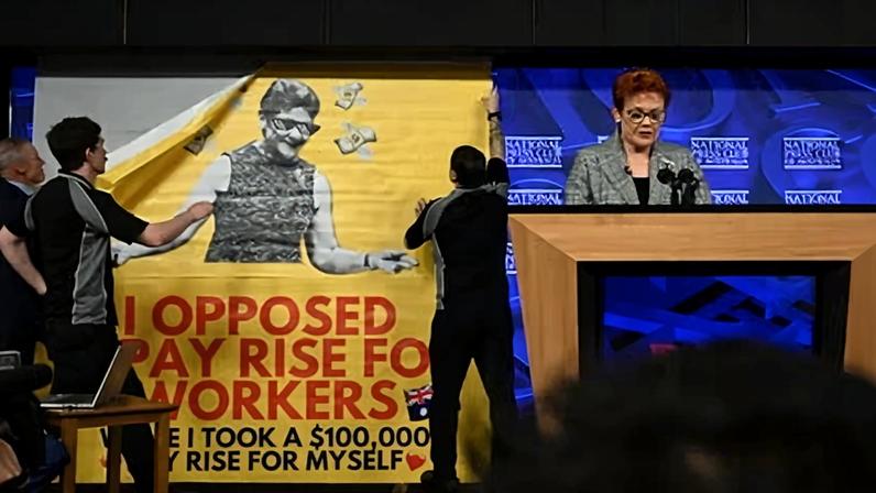 A banner was unfurled behind Pauline Hanson during her National Press Club speech.