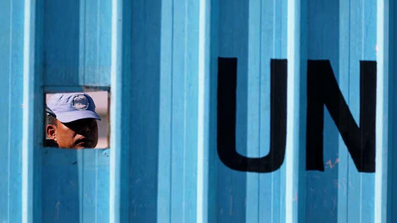Un casco azul de FINUL mira por una abertura de la base de la misión de la ONU en la localidad libanesa de Houla, cercana a Israel, el 2 de septiembre de 2019.